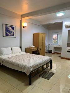 a bedroom with a large bed and a desk at Pikul Apartment Hotel in Nong Khai