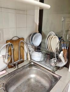 a kitchen sink with dishes in a drying rack at Melaka GX Homestay Seaview P0601 with Karaokae, TVBox, Snooker in Melaka