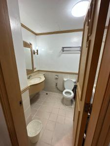 a small bathroom with a toilet and a sink at Canyon Cove by Lawton in Nasugbu