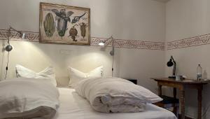 a bed with white pillows and a picture on the wall at Villa zur Erholung Bed & Breakfast in Bad Breisig
