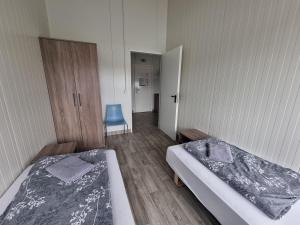 a room with two beds and a hallway with a door at Vlantana poilsio namai in Dauparai