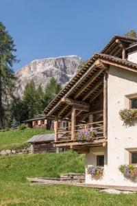 une maison avec une montagne en arrière-plan dans l'établissement Dolomites Luxe Cesa Del Louf, à Arabba 25 autres photos