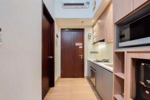 przedpokój z kuchnią z kuchenką mikrofalową i drzwiami w obiekcie Simply Look and Comfort Studio Room at Casa de Parco Apartment By Travelio w mieście Tangerang