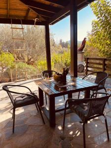 a wooden table and chairs on a patio at Thomas house in Archangelos +22 photos