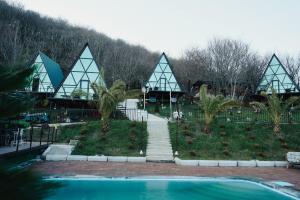 a resort with a swimming pool in front of a building at Panorama Sormoni in Dzhimastaro
