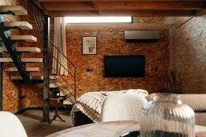 a living room with a couch and a television at Le Mas de l Olivier in Poulan-Pouzols