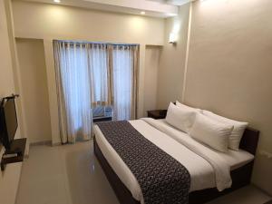 a bedroom with a large bed and a window at VITS Select Bharuch in Bharūch