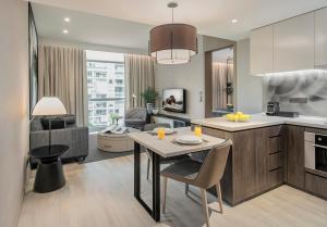 新加坡Ascott Orchard Singapore的配有桌椅的厨房和客厅