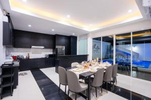 a kitchen and dining room with a table and chairs at White Chocolate Pool Villa Pattaya in Ban Huai Yai