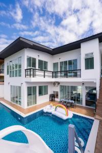 a house with a swimming pool and a house at White Chocolate Pool Villa Pattaya in Ban Huai Yai