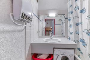 a bathroom with a sink and a washing machine at Granges 31 - Duplex 6pers Pied in Villard-Reculas