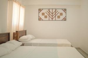 Ein Bett oder Betten in einem Zimmer der Unterkunft R2 Guest - HIKKADUWA