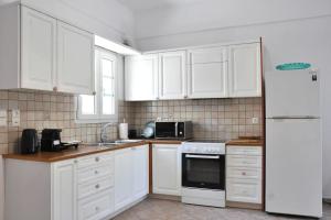 a kitchen with white cabinets and a white refrigerator at Mary & Jo's Studios in Naxos Chora +41 photos
