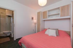 a bedroom with a bed with a red blanket at Apartment Lauro Opatija, ground floor, parking, near sea in Opatija
