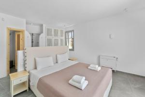 1 dormitorio blanco con 1 cama grande y 2 toallas en Seahorse Villa, en Makrotándalon 15 fotos más