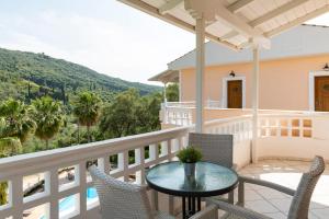 a patio with a table and chairs on a balcony at Golden Sun in Parga