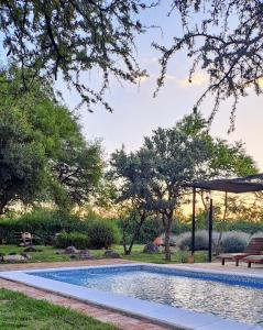 una piscina con una panchina e un ombrellone di Complejo Cabañas La Aguada a La Población