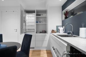 a kitchen with white cabinets and a sink at Apartment in Tromsø in Tromsø +23 photos