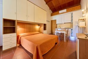 a small bedroom with a bed and a kitchen at Ghiacci Vecchi Residence in Venturina Terme