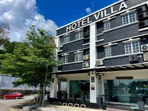 a hotel villa with a red car parked in front of it at Hotel Villa in Seremban