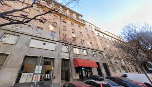 a large brick building with cars parked in front of it at Memo Apartment in Bologna