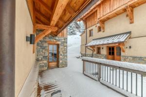 a balcony of a house with snow on the ground at Klochette - Charme Et Famille in Villard-Reculas