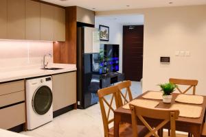a kitchen and dining room with a table and a dishwasher at Neem Luxury Apartment C in Al Fanātīr