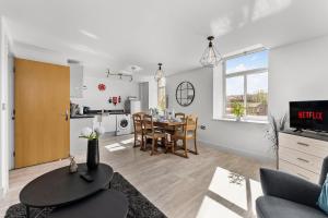 Una sala de estar con una mesa y un comedor. en 30 percent off! Beautiful Apartment in Dewsbury - Sleeps 6, en Leeds