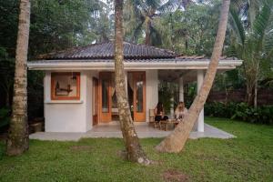 two people sitting at a table in front of a house at Studio Morell in Ahangama