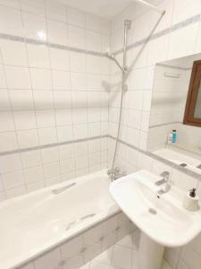 a white bathroom with a sink and a tub at Spacious Confortable Next Beach and Pintxos Area in Donostia-San Sebastián