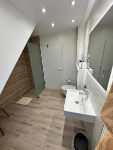 a bathroom with a sink and a toilet at Zwei Ferienwohnungen Anker max 5 Personen & Leuchtturm max 4 Personen, direkt in Steinhude Scheunenviertel, Balkon, WLAN , Privater Parkplatz, Wallbox in Steinhude