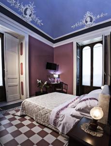 カターニアにあるArt Fashion House Luxury Roomsの紫の壁のベッドルーム1室、ベッド1台(テーブル付)