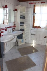 a white bathroom with two sinks and a window at Ferienhaus Annabell in Weisbach