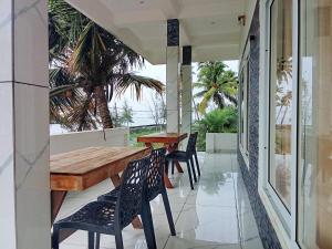 a porch with a wooden table and chairs at Appu's Nido in Pallipuram