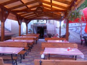 une rangée de tables et de bancs dans un restaurant dans l'établissement Pivnička pod Čachtickým hradom, à Čachtice