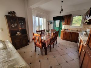 a kitchen with a table and chairs in a room at Το Μπαλκόνι της Ξανθής in Evdilos