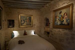 Tāmazrat的住宿－奧博格德塔梅滋利特酒店，卧室配有一张床,墙上挂有绘画作品