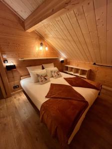 a bedroom with a large bed in a wooden ceiling at La Biche in Saint-Martin-sur-le-Chambre
