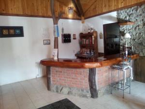 eine Bar in einem Zimmer mit Ziegelwand in der Unterkunft Hostería Altas Cumbres in El Chalten