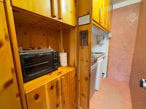 a small kitchen with a microwave on a wooden counter at Family Chalet in Pila, Comfort and Fun in Pila