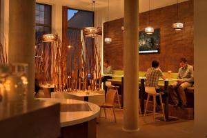 a group of people sitting at a table in a restaurant at MARA Hotel in Ilmenau