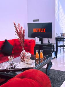 a living room with a red couch and a tv at CHAY - Signature Apartments in Ouarzazate +74 photos