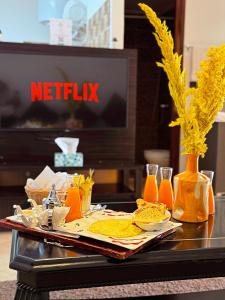 ワルザザートにあるCHAY - Appartements a Ouarzazateの食べ物とオレンジジュースのトレイ付きテーブル