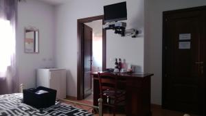 a bedroom with a desk and a bed and a mirror at Affittacamere Le Statue Del Sinis in Càbras