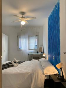 Un dormitorio con una cama con ventilador de techo. en Cardeñosa habitaciones, en Madrid