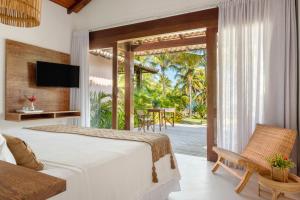 a bedroom with a bed and a view of a patio at Vila Bela Vista in Corumbau