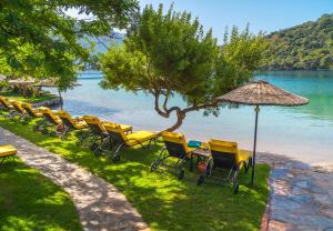 a row of chairs and an umbrella on a beach at Sundia By Liberty Suncity in Oludeniz