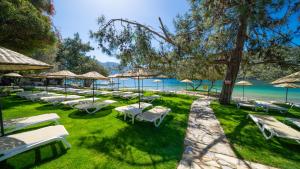 a group of lounge chairs and umbrellas on the beach at Sundia By Liberty Suncity in Oludeniz