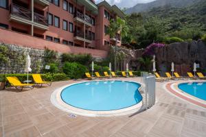 a resort with two pools and chairs and a building at Sundia By Liberty Suncity in Oludeniz