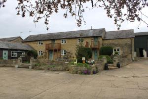 a large brick building with a yard with flowers at Lower Dovehouse in Warrington +5 photos